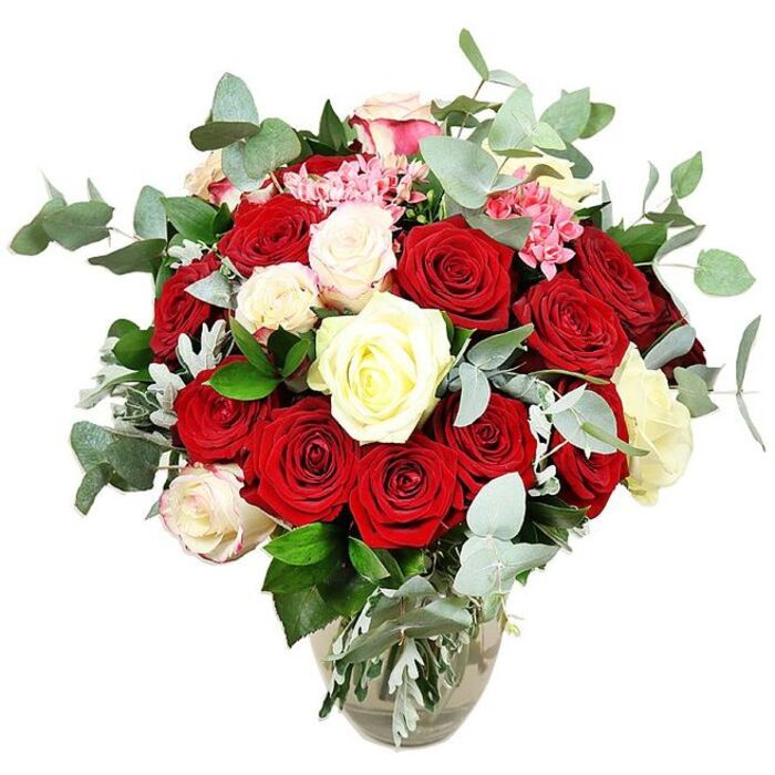 A lavish rose arrangement fills a clear glass vase, positioned against a stark white background that accentuates every nuance of colour and texture. The bouquet is composed primarily of luxuriant deep red and vivid scarlet roses, some still curled tightly at the centre, others fully opened to reveal layers of velvety petals that almost seem to glow with warmth and intensity. These rich tones are interwoven with roses in soft white and creamy ivory, plus a few white blooms whose gently blushed pink tips add a whisper of sweetness. Scattered among the larger flowers are dainty clusters of bright pink filler blossoms, which could be miniature carnations or similar small florets, giving the design a playful, almost sparkling quality. All around the roses, blue-green eucalyptus branches expand in soft, rounded sprays, the distinctive circular leaves lending a contemporary, airy structure and suggesting a cool, aromatic freshness that feels at home in Cranford's relaxed, leafy streets near Cranford Park. Deeper green foliage and slender silvery-green leaves weave through the base of the bouquet, adding density and framing the heads of the blooms, so the arrangement appears full and luxurious from top to bottom. The clear vase, slightly bulbous at the base and narrowing towards the neck, cradles the stems in clear water, the crossing lines of green visible through the glass and adding to the sense of natural elegance. Against the uncluttered white setting, the bouquet reads as a sophisticated, romantic statement piece, perfect for gracing a dining table, a hotel suite, or a special celebration at home, and it reflects the kind of careful, hand-crafted work you would expect from an experienced Cranford florist preparing flowers for a cherished anniversary or Valentine's surprise.